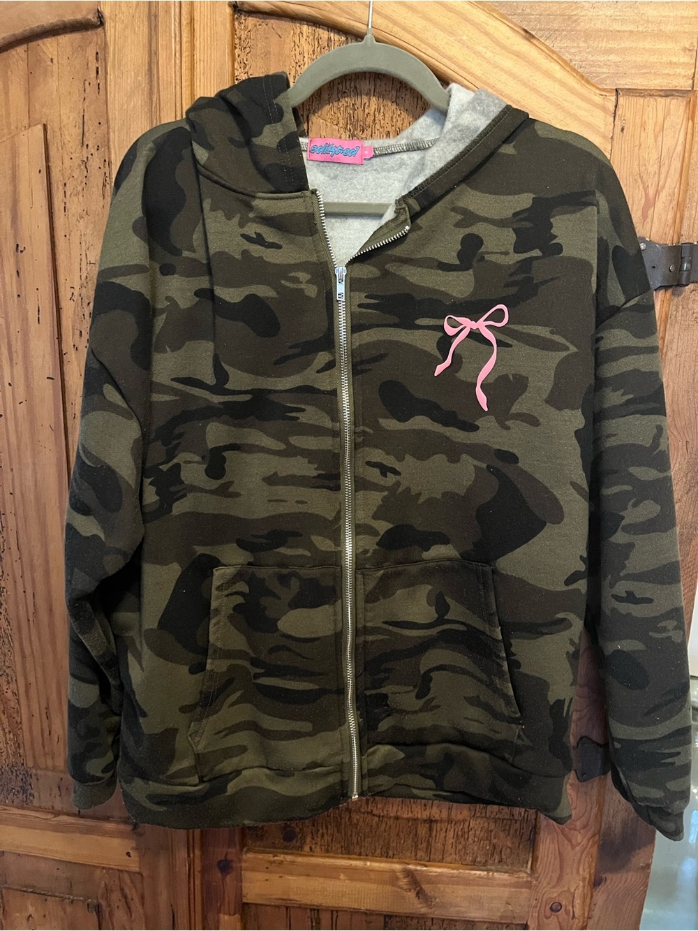 Edikted women’s Olive and Black Camo Zip Hoodie with Pink Bow